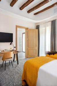 ein Hotelzimmer mit Bett, Schreibtisch und Computer in der Unterkunft Cal Roure Boutique Hotel in Igualada
