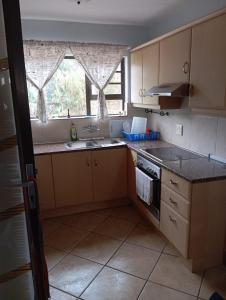 a kitchen with a sink and a stove and a window at Hibberdene See to Sea in Hibberdene