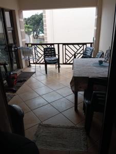 a room with a table and chairs on a balcony at Hibberdene See to Sea in Hibberdene