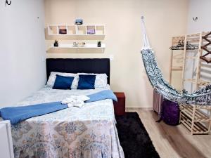a bedroom with a bed and a hammock at Hospedagem Aconchego do Lar in Barreirinhas