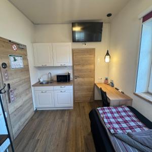 a small kitchen with white cabinets and a bed in a room at Rose Boardinghouse 24h-7d Self Check-In Automat in Großbottwar