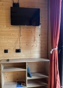 a room with a wooden wall with a flat screen tv at "Panorama" Kakhri in Mestia