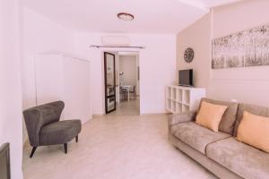 a living room with a couch and a chair at Appartamenti I Lentischi in Villasimius