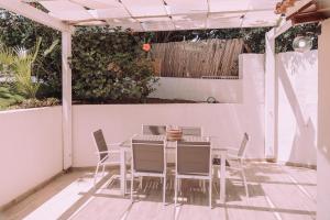 a table and chairs on a patio with a hedge at Appartamenti I Lentischi in Villasimius