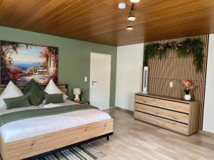 a bedroom with a large bed and a painting on the wall at Apartment Leidenberger - Nähe Rothenburg & Ansbach - 2 Schlafzimmern in Colmberg