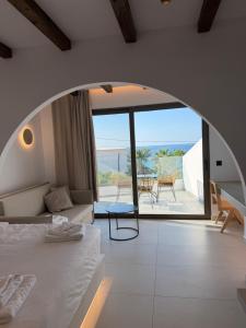 a bedroom with a bed and a view of the ocean at Salt and stone suites in Vrachonisída touArchangélou