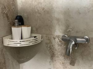 a toilet paper holder on a wall with a faucet at AmurRelaxCreative in Khmelnytskyi