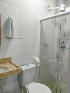 een badkamer met toilet en een glazen douche bij Costa Suítes in Maragogi