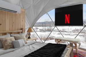 a bedroom with a tv with the letter n on it at Johnson Dome in Johnson