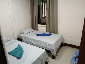 two beds in a small room with blue sheets at Señora Aura in Hone Creek