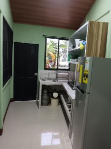 an empty kitchen with a refrigerator and a door at Señora Aura in Hone Creek