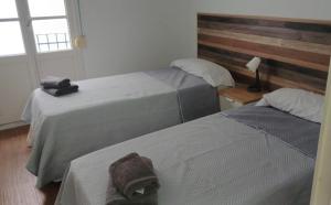 a bedroom with two beds and a lamp and a window at Sunny terrace flat in Ceuta