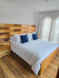 a bedroom with a large bed with blue pillows at Hospedaje Vista Hermosa Salento in Salento +147 photos