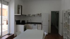 a kitchen with white cabinets and a table and a window at Sunny terrace flat in Ceuta