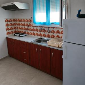 a kitchen with a sink and a white refrigerator at Mimika studios in Pefki