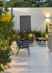 a patio with chairs and tables and a table at شالية بمسبح وجلسة خارجية- غرفتين نوم وملحق خارجي ومدخل سيارة in Unayzah