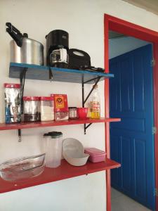 a kitchen with a red shelf with food on it at Casinha Centro histórico in Paraty