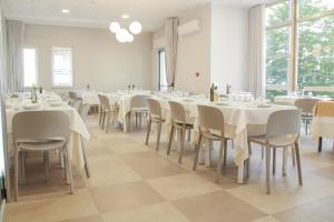 a dining room with white tables and chairs at HOTEL BALTIC in Alba Adriatica