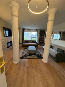 a living room with white columns and a couch at El Cubanito Athéna - Résidence de Standing - 2 Chambres - 4 Couchages - 8 Personnes Max - Parking Privé - Gare à 8 min in Cergy