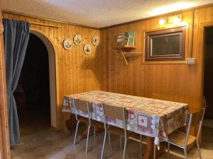 a dining room with a table and chairs and a television at Baita Palue in Torcegno +9 photos