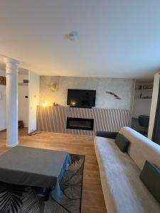 a living room with a couch and a flat screen tv at El Cubanito Athéna - Résidence de Standing - 2 Chambres - 4 Couchages - 8 Personnes Max - Parking Privé - Gare à 8 min in Cergy