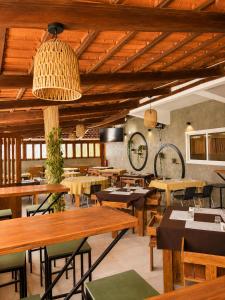 a restaurant with wooden tables and wooden ceilings at Djeu Guest House in Santa Maria