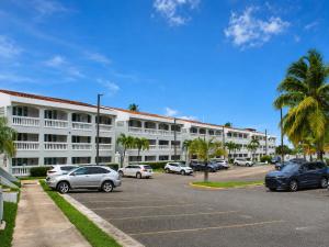a large white building with cars parked in a parking lot at Golden Dream Studio 2nd floor B in Isabela