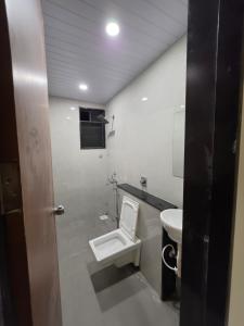 a bathroom with a toilet and a sink at NilayInn in Pandharpur
