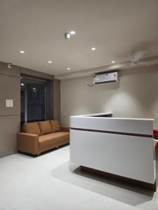 a living room with a couch and a white counter at NilayInn in Pandharpur +1 photo