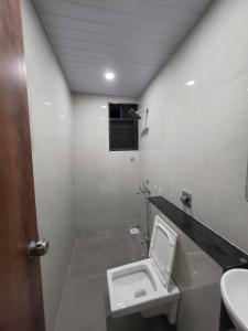 a bathroom with a toilet and a sink at NilayInn in Pandharpur