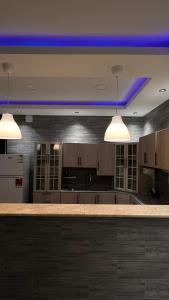 a kitchen with two lights and a blue ceiling at شالية بمسبح وجلسة خارجية- غرفتين نوم وملحق خارجي ومدخل سيارة in Unayzah