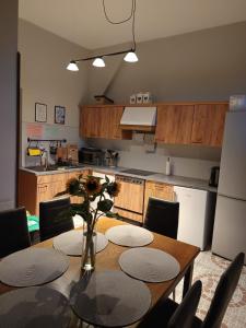 a kitchen with a wooden table with chairs and a dining room at 117 in Łeba