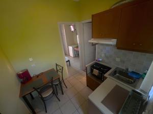 a small kitchen with a table and chairs and a table and a stove at Ionian Bay Studios in Lefkada