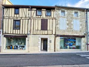 an old building with windows on a city street at Le Saint July in Eauze