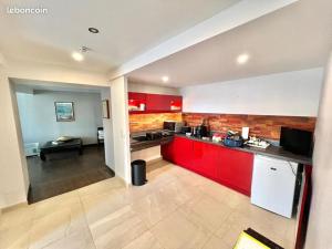 a kitchen with red cabinets and a counter top at Le Saint July in Eauze
