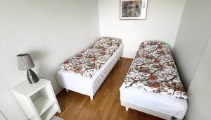 a small room with two beds and a lamp at HHH Modern flat centrally located in Helsinki, close to Pasila railway station in Helsinki