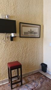a picture on a wall with a stool and a television at Millys Guesthouse Jhb in Johannesburg