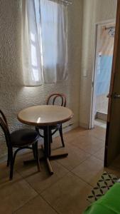 a table and chairs in a room with a window at Millys Guesthouse Jhb in Johannesburg