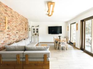 a living room with a couch and a brick wall at Dom pod strzechą in Swornegacie
