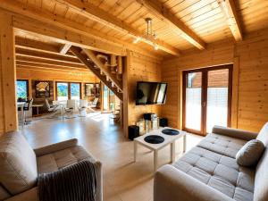 a living room with a couch and a tv at Domki na Szlaku in Brenna