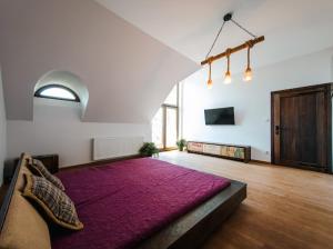 a large bed in a room with a purple rug at Dom pod strzechą in Swornegacie