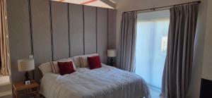 a bedroom with a bed with red pillows and a window at Villa Cañicosa in Cañícosa
