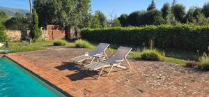 two lawn chairs sitting next to a swimming pool at Villa Cañicosa in Cañícosa