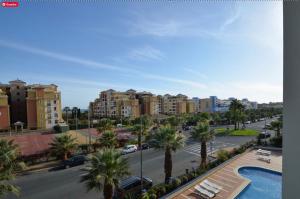 a view of a street with palm trees and buildings at La Marina Solmares in Isla del Moral