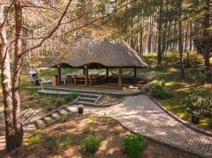 a gazebo in a park with a tree at Dom pod strzechą in Swornegacie