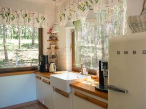 a kitchen with a sink and a white refrigerator at Dom pod strzechą in Swornegacie