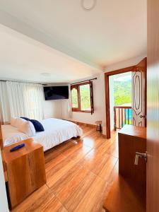 a bedroom with a bed and a wooden floor at Hospedaje Vista Hermosa Salento in Salento