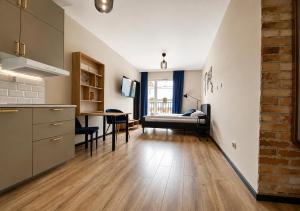 a kitchen and a living room with a bed and a table at CudNajem Old Town Apartments - Bulvar in Elblag