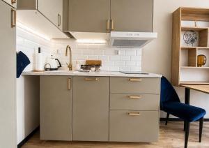 a kitchen with a sink and a blue chair at CudNajem Old Town Apartments - Bulvar in Elblag +4 photos