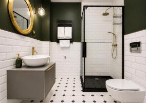 a bathroom with a sink and a toilet and a shower at CudNajem Old Town Apartments - Bulvar in Elblag